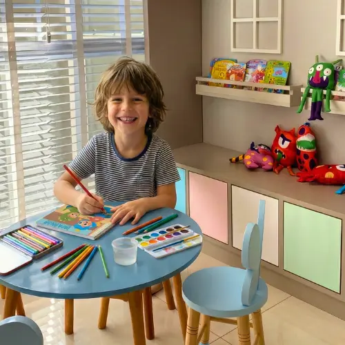 Criança feliz colorindo o livro Fada Falah